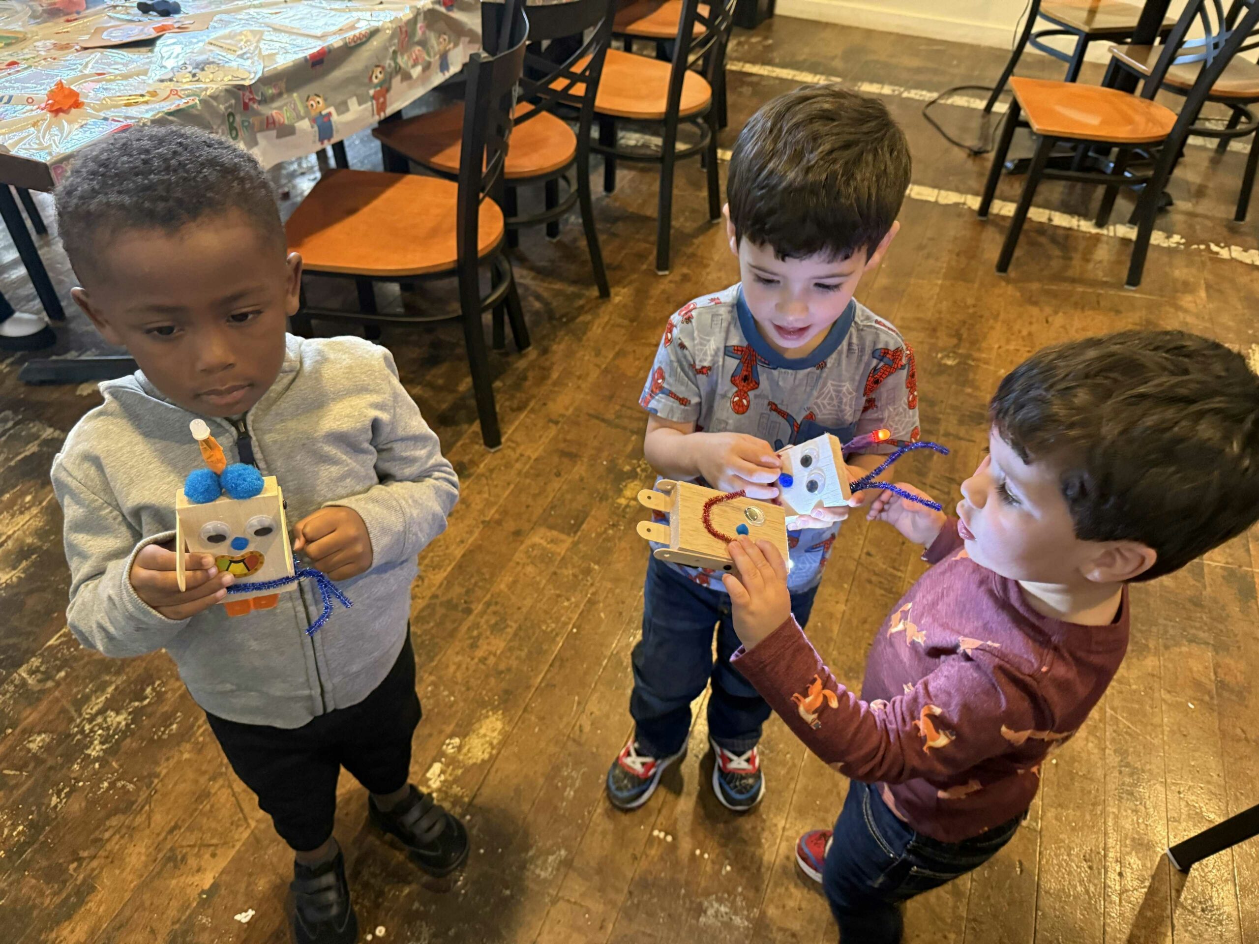 Photo: 3 kids hold the robots they just built