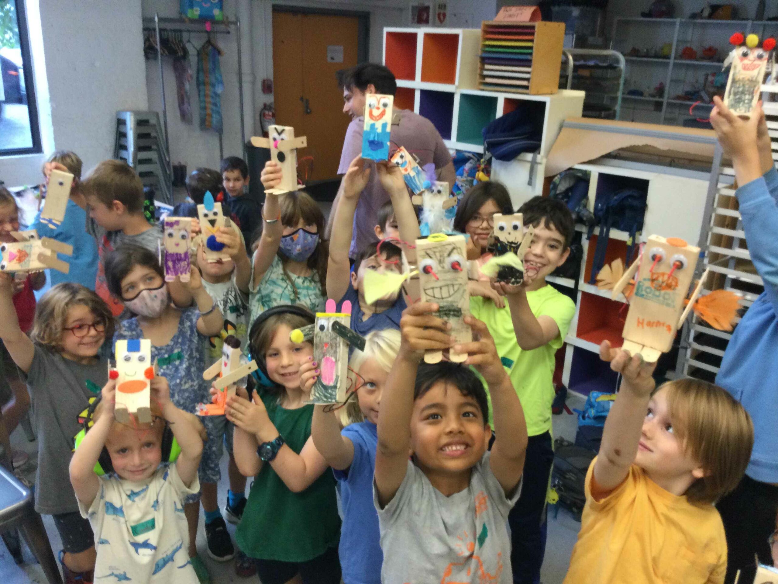 Photograph of about 15 kids proudly holding up the robots they built